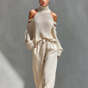 Set aus einem gestrickten Damen-Rollkragenpullover mit Cold-Shoulder-Ausschnitt und einer Hose mit weitem Bein