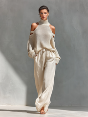 Set aus einem gestrickten Damen-Rollkragenpullover mit Cold-Shoulder-Ausschnitt und einer Hose mit weitem Bein