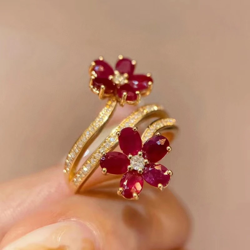 Goldfarbener Spiralring mit roten Gänseblümen